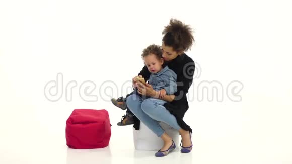 非裔美国人的母亲和她的孩子坐在一起拿着一部电话白色背景慢动作视频的预览图