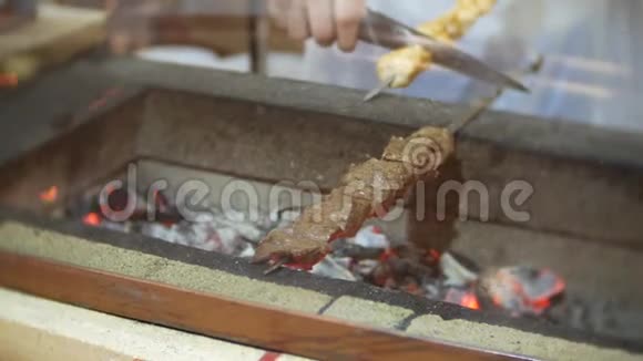 烤架上的烤串厨师在烤架上准备一个什什烤肉串4k视频的预览图