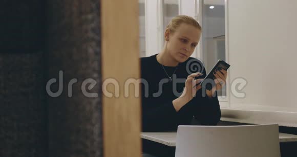 咖啡馆里的女人在手机上发短信视频的预览图