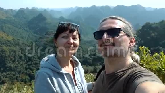 微笑情侣在山区背景下自拍视频的预览图