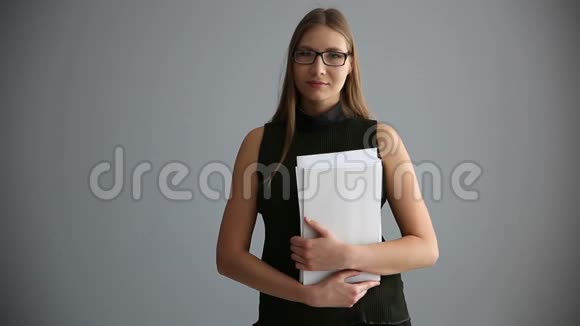 一个商业女孩的肖像文件靠近灰色的墙快乐的上班族女人视频的预览图
