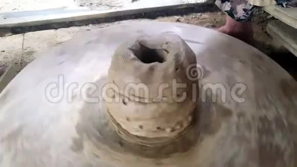 巨锅形状旋转在陶轮老女人添加泥卷视频的预览图