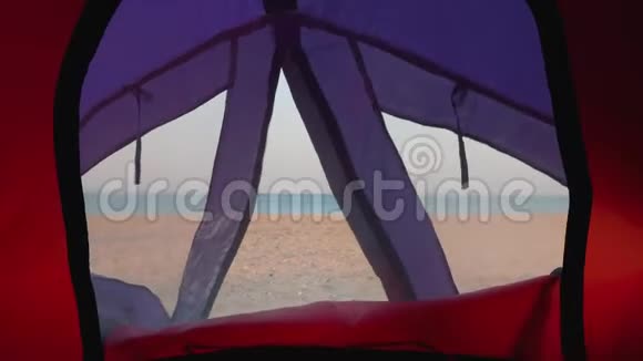 从帐篷里的小窗户看到荒芜的海滩和蓝色的大海视频的预览图