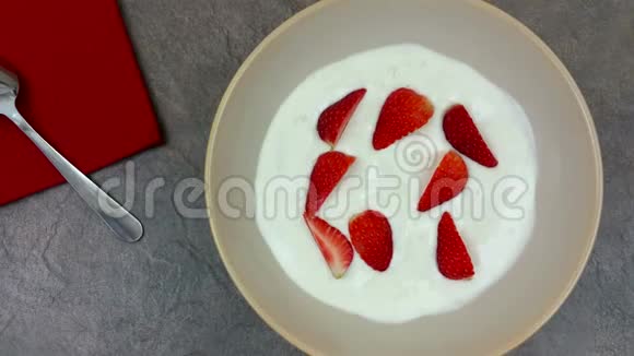 旋转的酸奶与大块新鲜成熟的草莓视频的预览图