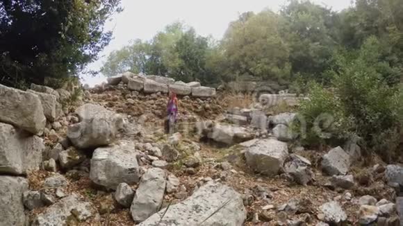 女孩看到巨大的石头摧毁了古罗马剧院的废墟奥利姆波斯古城的森林在地中海视频的预览图