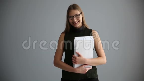 一个商业女孩的肖像文件靠近灰色的墙快乐的上班族女人视频的预览图