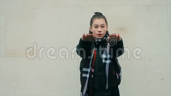 穿着黑色衣服的女人化妆在白色砖墙上跳舞视频的预览图
