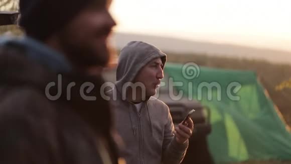 在日落时带着两个男人参加探险露营视频的预览图