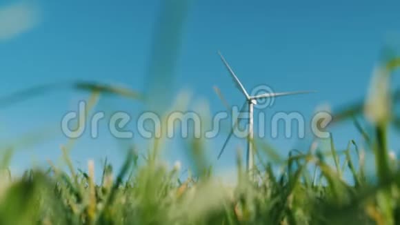 一台风力发电机前景一片绿草清洁能源和环境概念视频的预览图