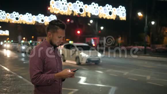年轻人在户外使用现代智能手机男人在社交网络上和朋友聊天散步视频的预览图
