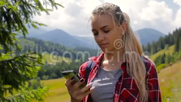 年轻漂亮的女孩在山里用手机打电话视频的预览图