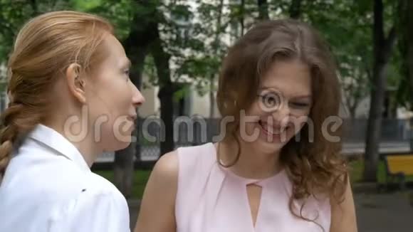 两个女朋友在公园里聊天一个阳光明媚的夏天特写镜头视频的预览图