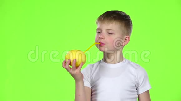 孩子用吸管拿着柠檬喝柠檬汁竖起大拇指绿色屏幕慢动作视频的预览图