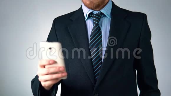 一个西装打领带的商人手里拿着一部手机外观时尚优雅视频的预览图