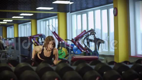 一个运动的女人看着镜子泵着前臂的肌肉视频的预览图