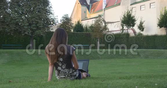 城市花园里有笔记本电脑的女人视频的预览图