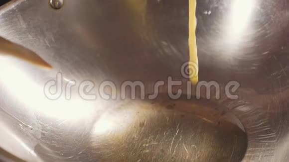在炒锅里倒入煮油的鸡蛋煎蛋卷特写过程视频的预览图