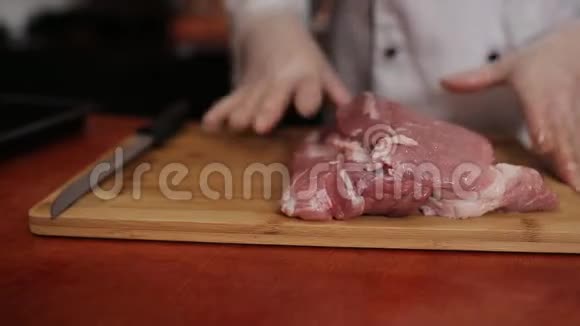 女厨师在餐厅的切肉板上切猪肉视频的预览图