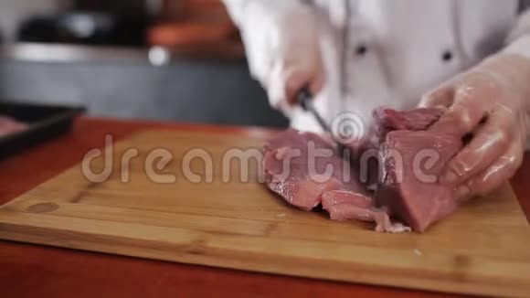 女厨师在餐厅的切肉板上切猪肉视频的预览图
