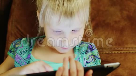 小女孩深夜在平板电脑上玩耍的肖像视频的预览图