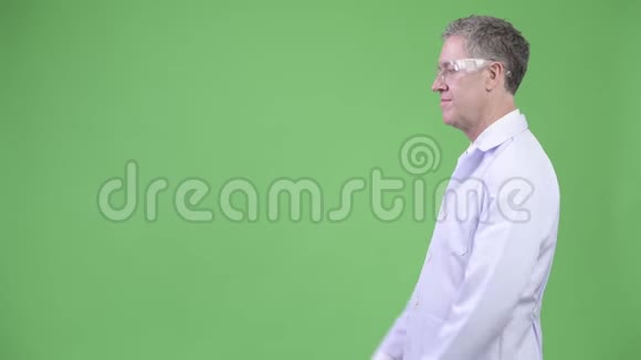 带防护眼镜的成熟男性医生的侧写视图视频的预览图