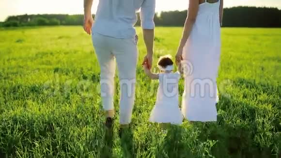 一家人在公园散步小女儿迈出了第一步全都穿着白色的衣服在夕阳下视频的预览图
