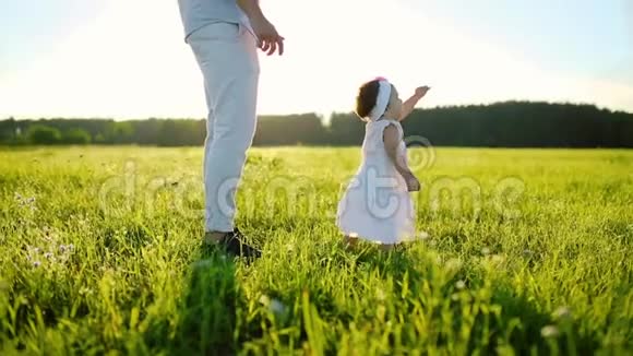一家人在公园散步小女儿迈出了第一步全都穿着白色的衣服在夕阳下视频的预览图