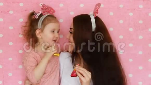 母女俩吹响党角微笑欢笑庆祝生日快乐一个女人和她的孩子视频的预览图