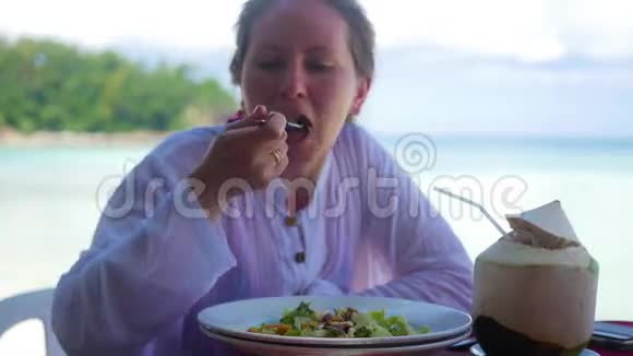 那个女孩正在海滩上的餐馆吃饭视频的预览图
