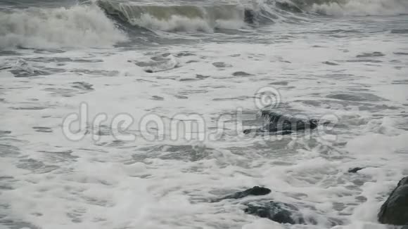 一股长而泡沫的波浪缓慢地向岸边翻滚视频的预览图