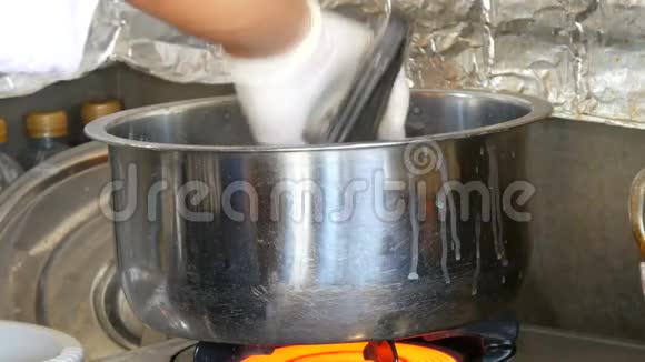 戴着白手套的厨师正在煮东西在大锅上搅拌视频的预览图