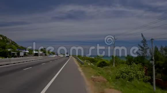 沿着高速公路行驶经过海滩和丘陵景观视频的预览图