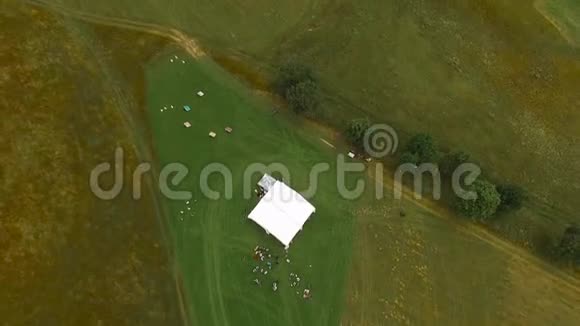 用无人驾驶的田野和白色的帐篷和人从空中射击视频的预览图