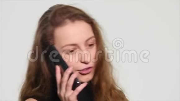 愤怒的年轻女子在白色背景下用手机说话视频的预览图