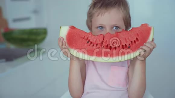 快乐的男孩吃着红色的西瓜和在牙齿下流动的果汁视频的预览图