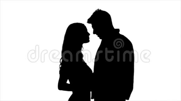 相爱的夫妇互相看着对方开始接吻剪影白色背景慢动作视频的预览图