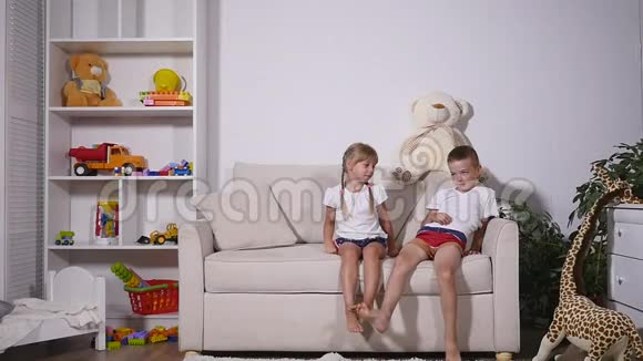 两个男孩和女孩在沙发上和解慢动作视频的预览图