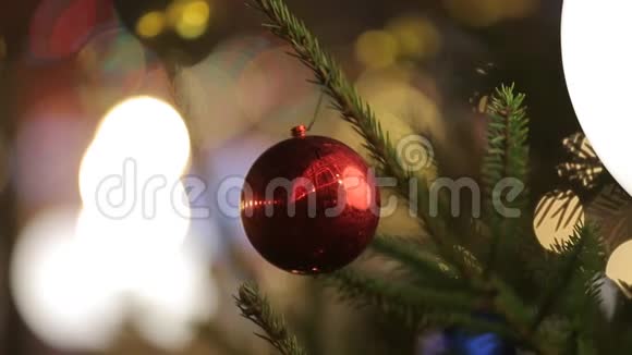 背景上一棵圣诞树上挂着一个闪亮的大红球特写视频的预览图