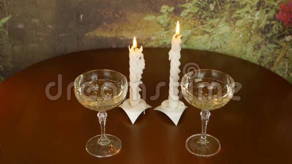 慢动作特写家庭厨房深色木桌上的配对眼镜两盏蜡烛燃灯吹蜡烛和烟视频的预览图