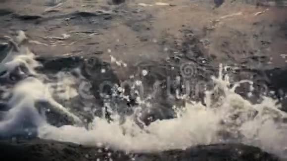 暗水在岩石上产生波浪缓慢运动视频的预览图