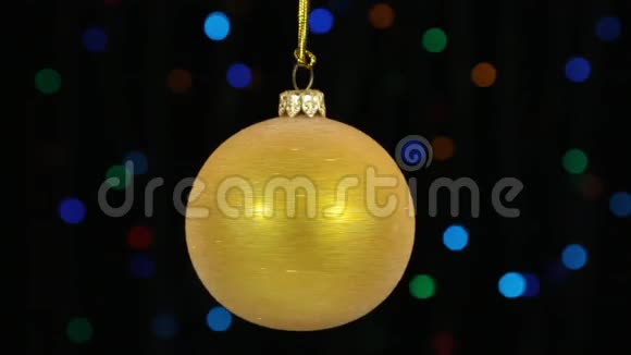 特写旋转的黄色圣诞球挂在一根金色的绳子上圣诞节和新年装饰视频的预览图