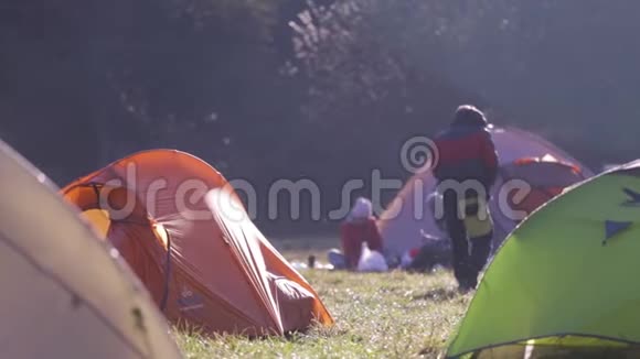 在秋天雾蒙蒙的早晨在森林的绿草上有帐篷的营地秋天周末森林徒步旅行带帐篷视频的预览图