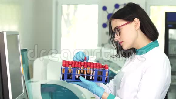 年轻的女科学家用血样检查试管视频的预览图