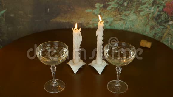 木桌上两个玻璃一对蜡烛耀斑吹得无遮拦从一支绝迹的蜡烛中流出的烟视频的预览图