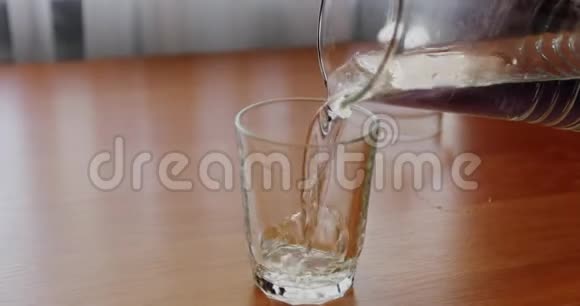 一个戴着医用手套的护士从罐子里把水倒进杯子里视频的预览图