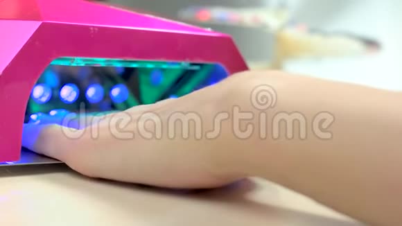 女人在专用机器上烘干指甲视频的预览图