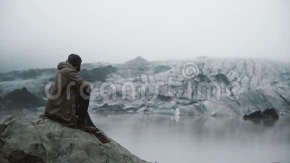 年轻的帅哥在冰泻湖欣赏美丽的冰川景观独自探索冰岛的男性视频的预览图
