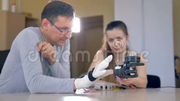一男一女正在测试仿生手臂动动手指4K视频的预览图