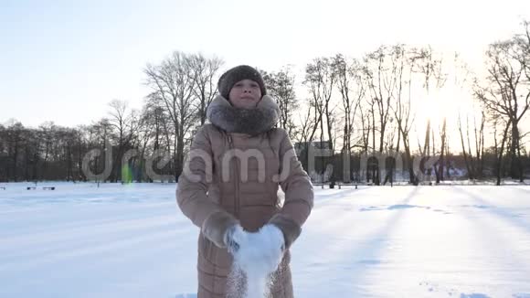 小女孩在冬天的公园里扔雪微笑着圣诞节假期慢动作视频的预览图