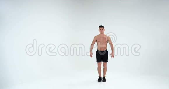 在白色背景下穿着紧身衣的人在缓慢的运动中展示他的肌肉4k视频的预览图